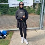 woman in sunglasses holding tennis racket